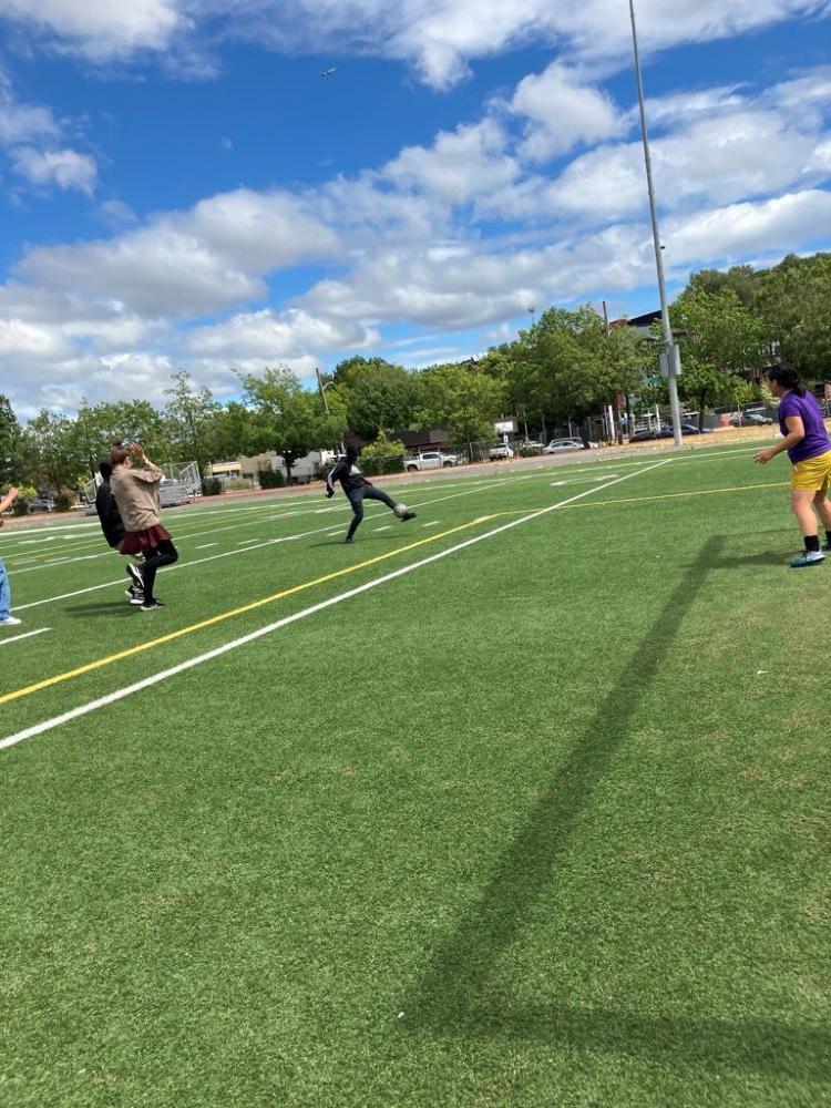 Students playing soccer with teacher